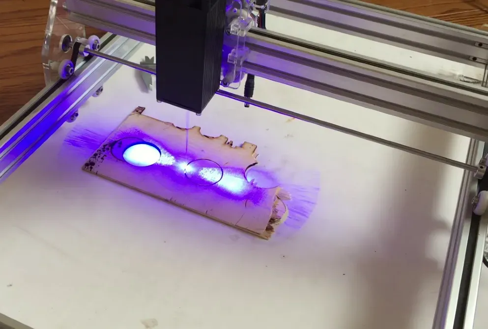 Лазерлік гравер, лазер әсер ететін аумақта ағаш бетін өңдеу.