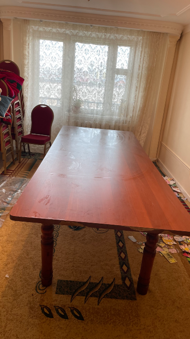 Терезе мен орындықтардың фонында ағаш үстелдің кең көрінісі