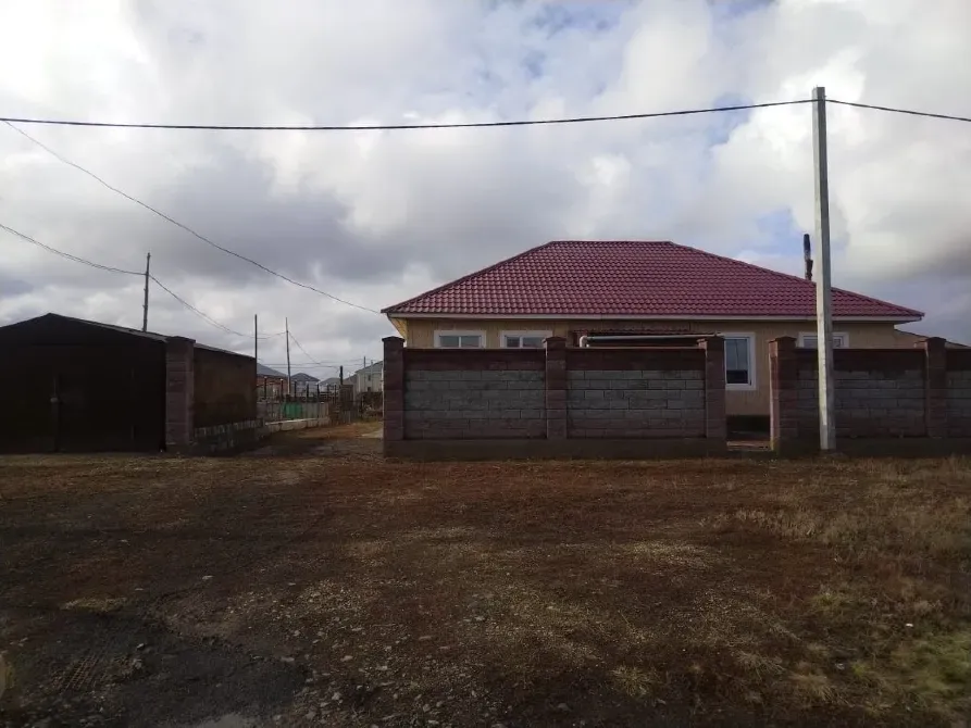 Дом с черепичной крышей и забором, расположенный вдали от города