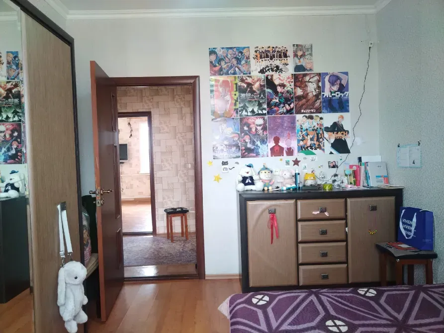 Комната с постерами на стенах и игрушками на комоде