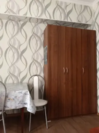 Уютная столовая с деревянным шкафом и столом
