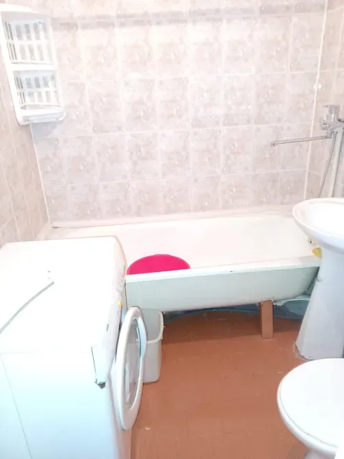 Современная ванная комната с ванной, стиральной машиной и умывальником