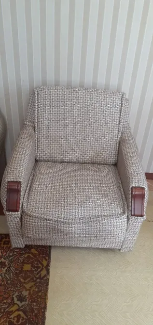 Кресло с тканевой обивкой и деревянными подлокотниками