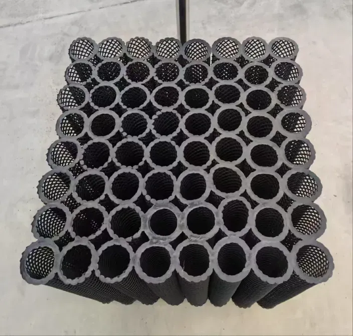 Чёрные сетчатые трубы, уложенные в квадрат, образующие упорядоченную конструкцию с полыми центрами