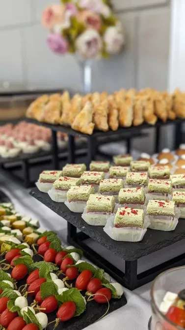 Разнообразные закуски и десерты на белом столе, аккуратно разложенные