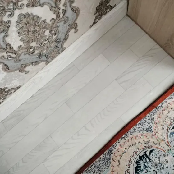 Пол с белыми деревянными планками и нежным узором на обоях