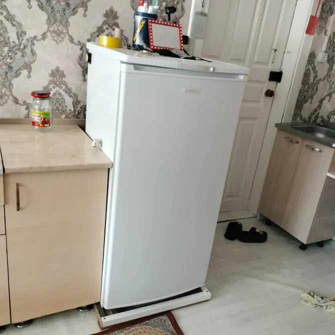 Холодильник на кухне рядом с рабочей поверхностью и стеной с узором