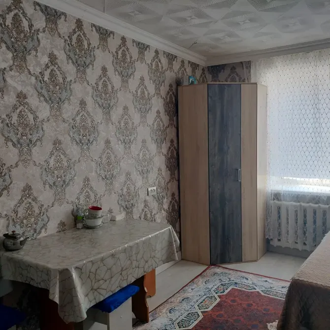 Интерьер комнаты с декоративными стенами и мебелью, включая шкаф и стол