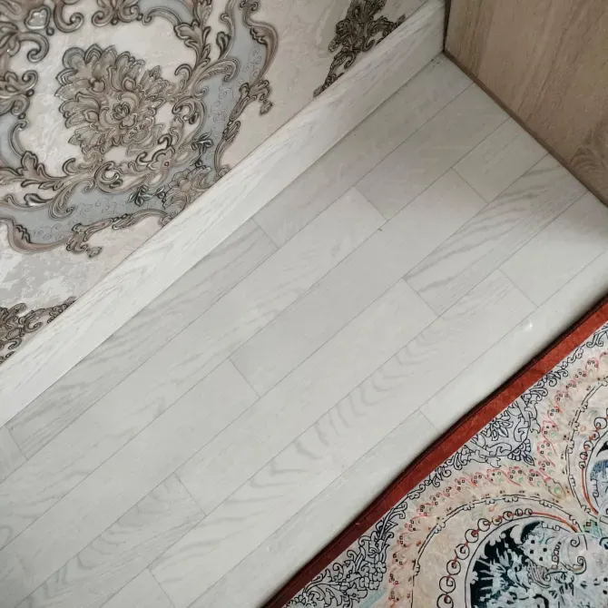 Пол с белыми деревянными планками и нежным узором на обоях