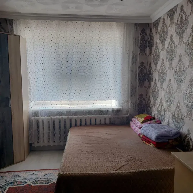 Спальня с окном, кроватью и уютным текстилем на стуле