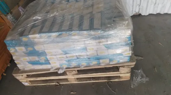 Куча упакованных коробок на деревянном поддоне в упаковке из пленки