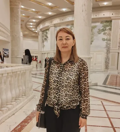 Женщина в леопардовой рубашке стоит в элегантном интерьере с колоннами и росписью на стенах