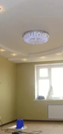 Потолок с люстрой и точечными светильниками в светлом помещении
