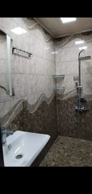 Заманауи ванна бөлмесі плиткамен және душ кабинасымен