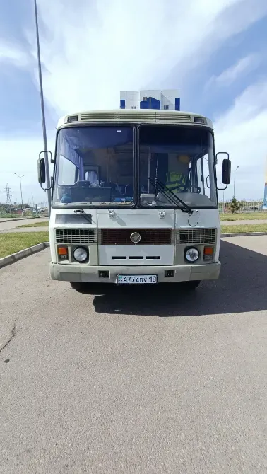 Парковкадағы ескі автобустың алдыңғы көрінісі, нөмірі бар