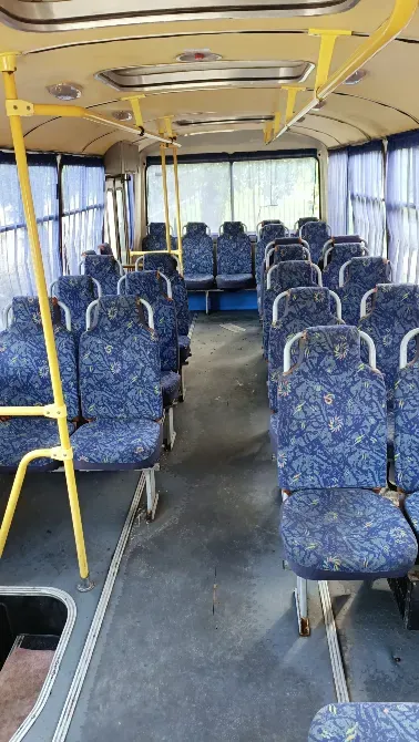 Қалалық автобустың интерьері, қара орындықтармен және бос қатарлармен