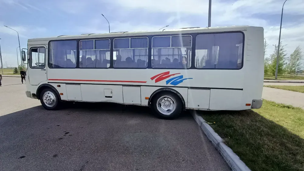 Автобустың бүйірлік көрінісі, тұрған ақ автобуста бос терезелер