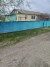 қоршауы бар үй және жасыл металлы дахта