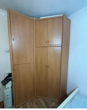Шкаф с закрытыми дверцами, вид сбоку, стены около кровати