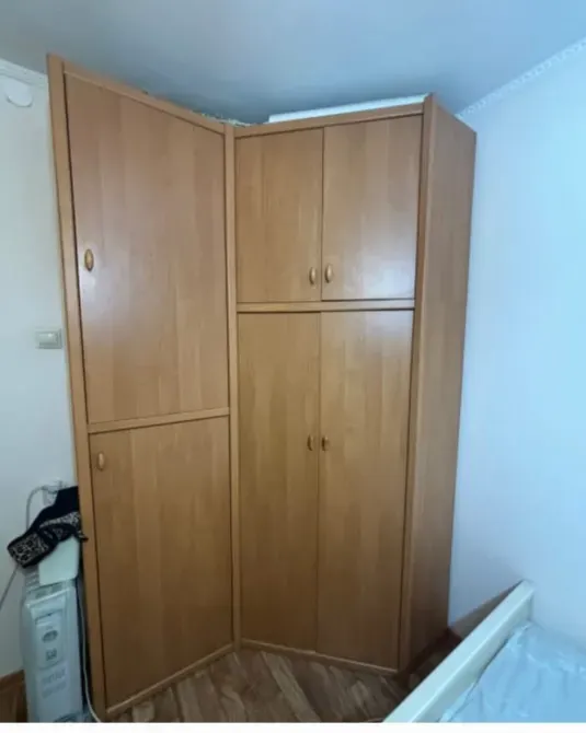 Шкаф с закрытыми дверцами, вид сбоку, стены около кровати