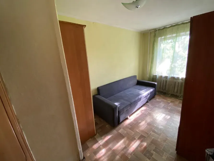 Сұр диваны және үлкен терезесі бар бөлме