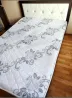 Декоративті өрнекпен ақ фондағы матрас, жұмсақ жастықшасы бар төсек