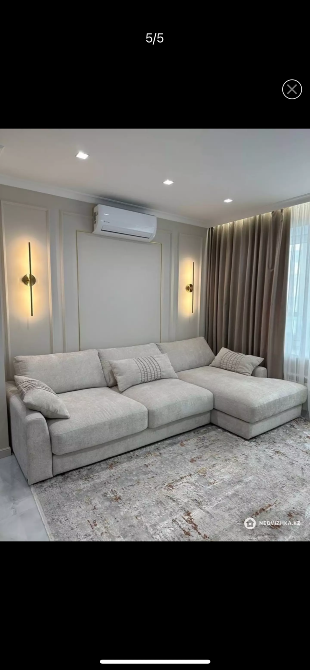 Жарық және жайлы бұрыш сары диванмен және текстуралы кілеммен