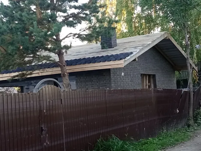 Чёрный дом с крышей, отделанный плиткой, вид сбоку