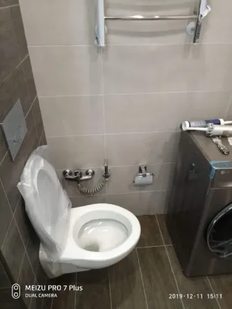 туалет с унитазом и стиральной машиной в ванной комнате