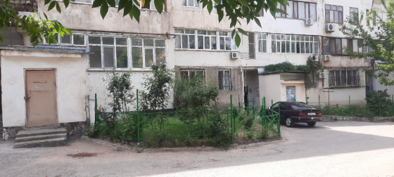 Тұрғын үйдің фасады, көлік және жасыл алаңы бар
