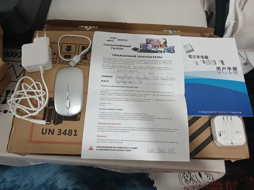 Зарядтау құрылғысы, тышқан және құжаттармен бірге пакеті, қораптың фонында