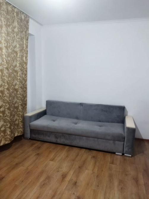 Комната с серым диваном и шторами