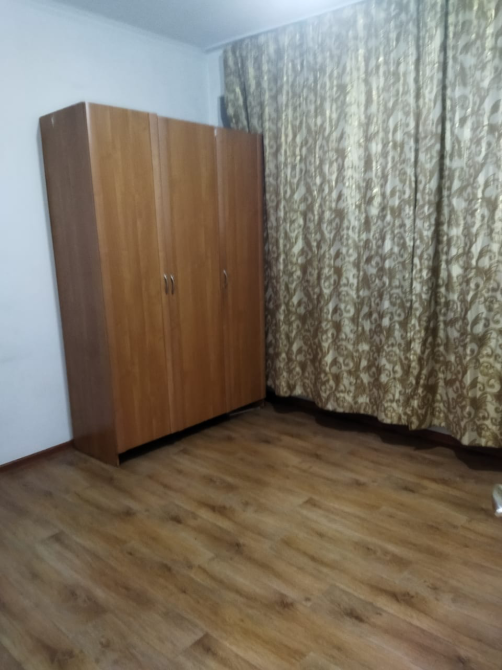 Интерьер другой комнаты с деревянным шкафом и шторами