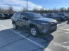 Жаңа сары внедорожник Toyota Rav4 автотұрақта, ағаштар фонында