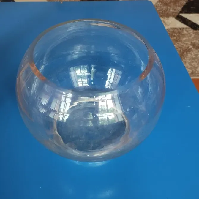 Көк фондағы дөңгелек пішінді мөлдір шыны ваза