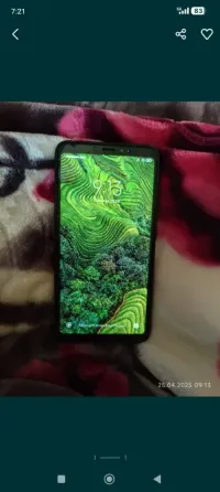 Жарық экранды смартфон, жасыл террасалық алаңдардың суретін көрсетеді.