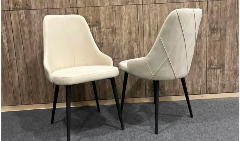 два светлых стула с черными ножками на фоне дерева