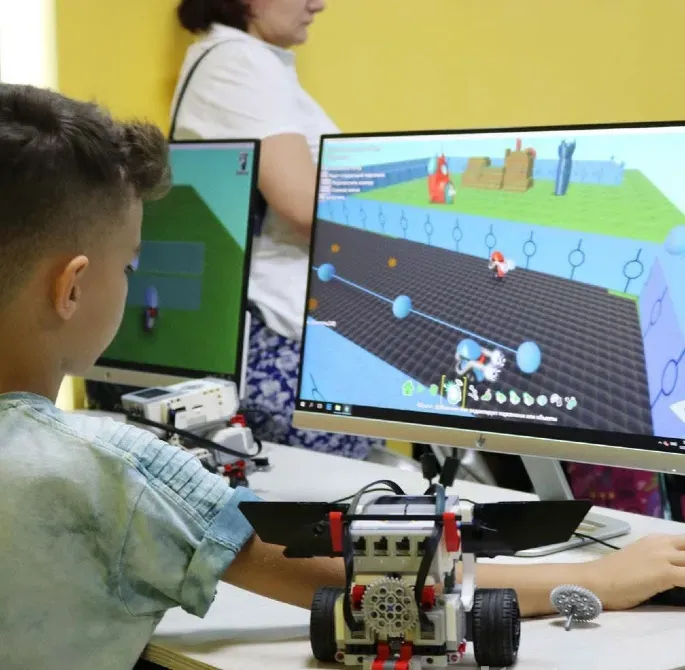 Ребенок за компьютером, играющий в образовательную игру