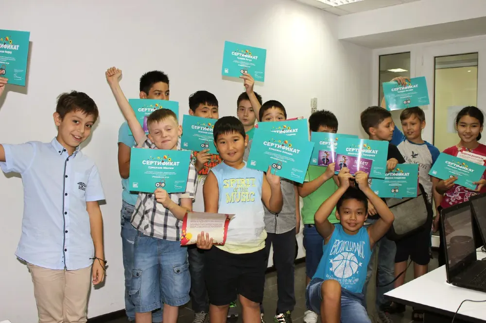 Группа детей с сертификатами об окончании курса, празднующих успех