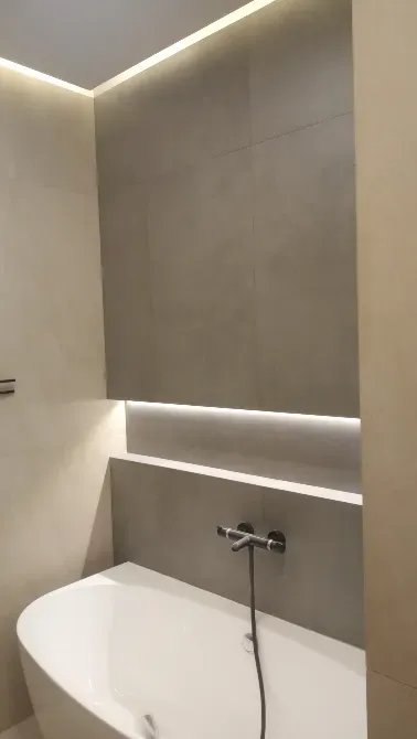 Современная ванная комната с ванной и скрытой подсветкой