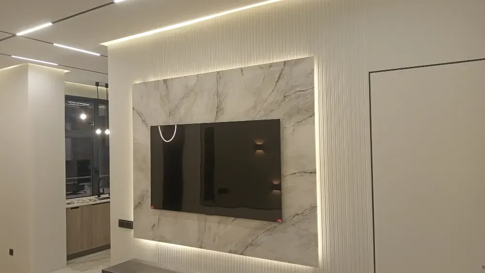 Стена с телевизором, декорированная мрамором и светодиодной подсветкой