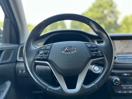 Рулевое колесо черного Hyundai Tucson с элементами управления и логотипом Hyundai