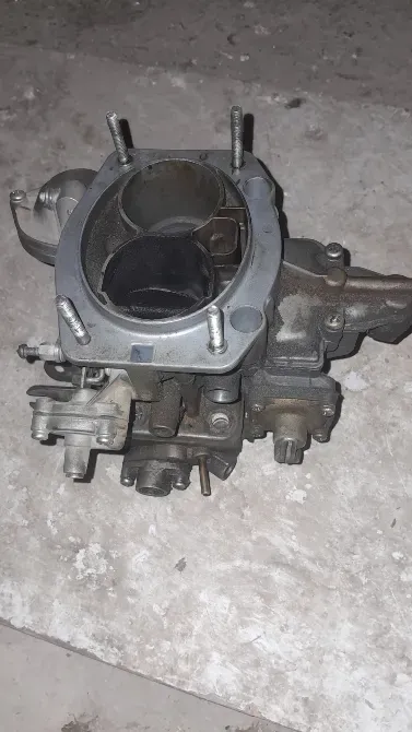 Карбюратор с деталями и крепежом на поверхности