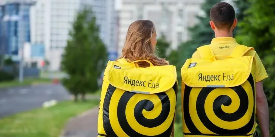 Два курьера с рюкзаками Яндекс Еда, вид сзади