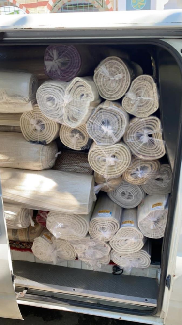 Түрлі түсті ковер рулондары, фургонда мұқият жинақталған