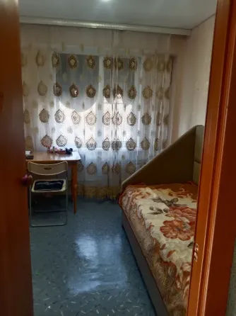 Спальня с кроватью и столом рядом с окном