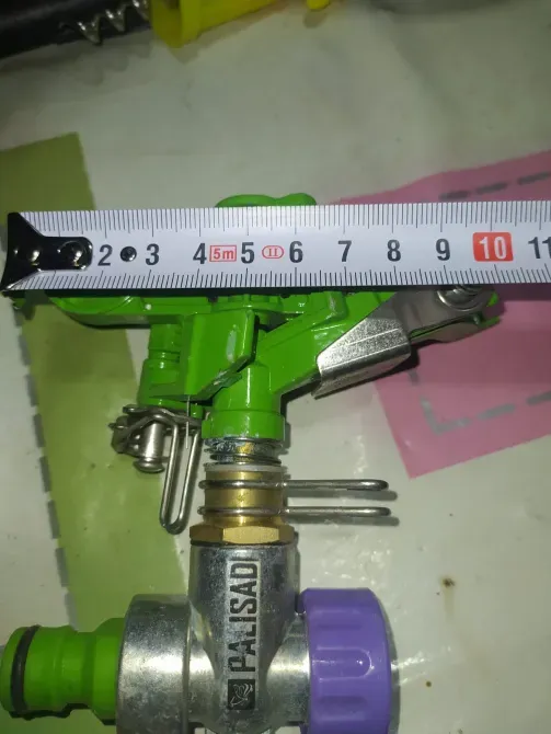 Изображение 2: Крупный план детали поливного устройства с измерительной лентой