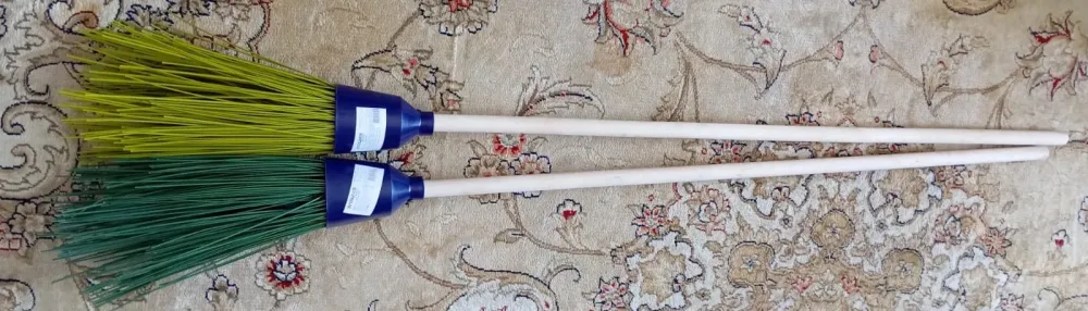 Две метлы на ковровом покрытии с разноцветными щетками