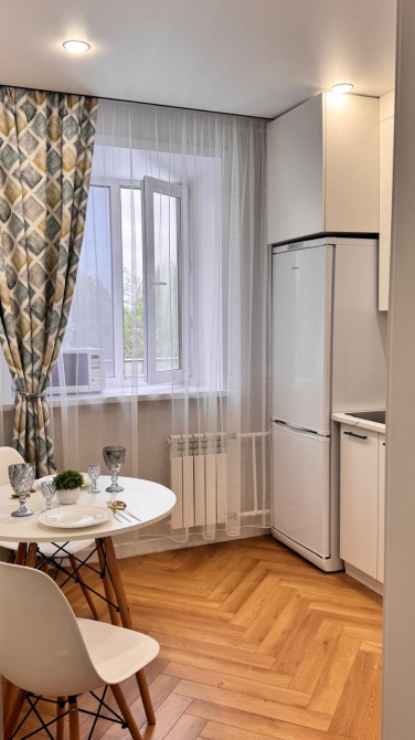 столовая зона с белым столом и холодильником