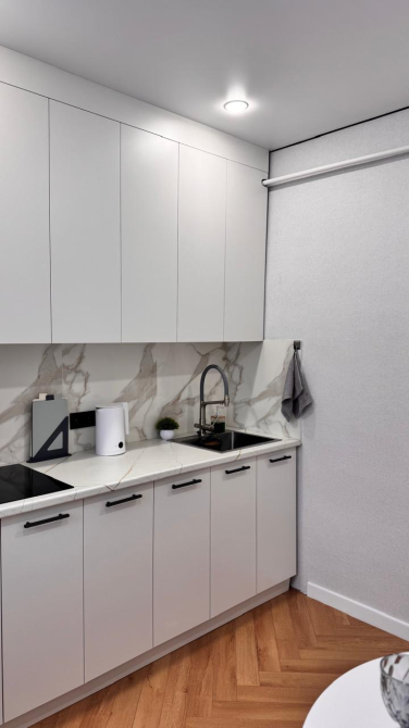 кухня с белыми шкафами и современной техникой